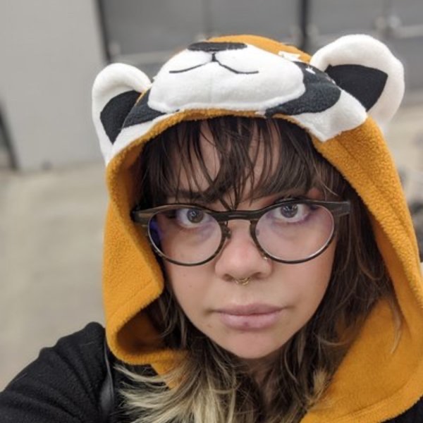 Young asian woman with dark hair and glasses wearing a red panda kigarumi
