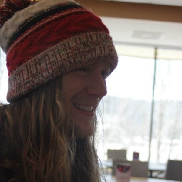 Young caucasian man with red beard and long hair wearing beanie.